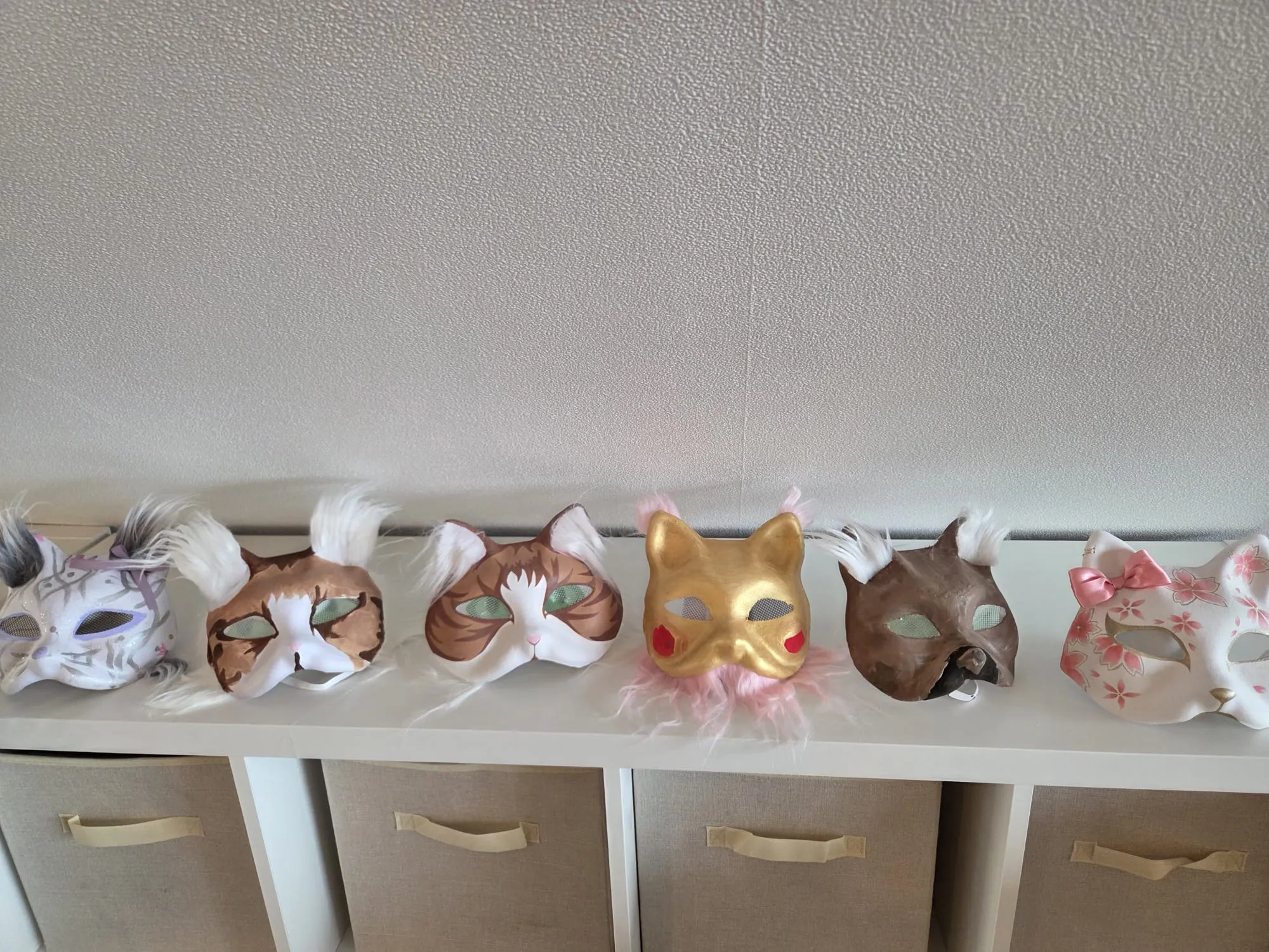 Von Kindern bemalte Tiermasken in einer Reihe